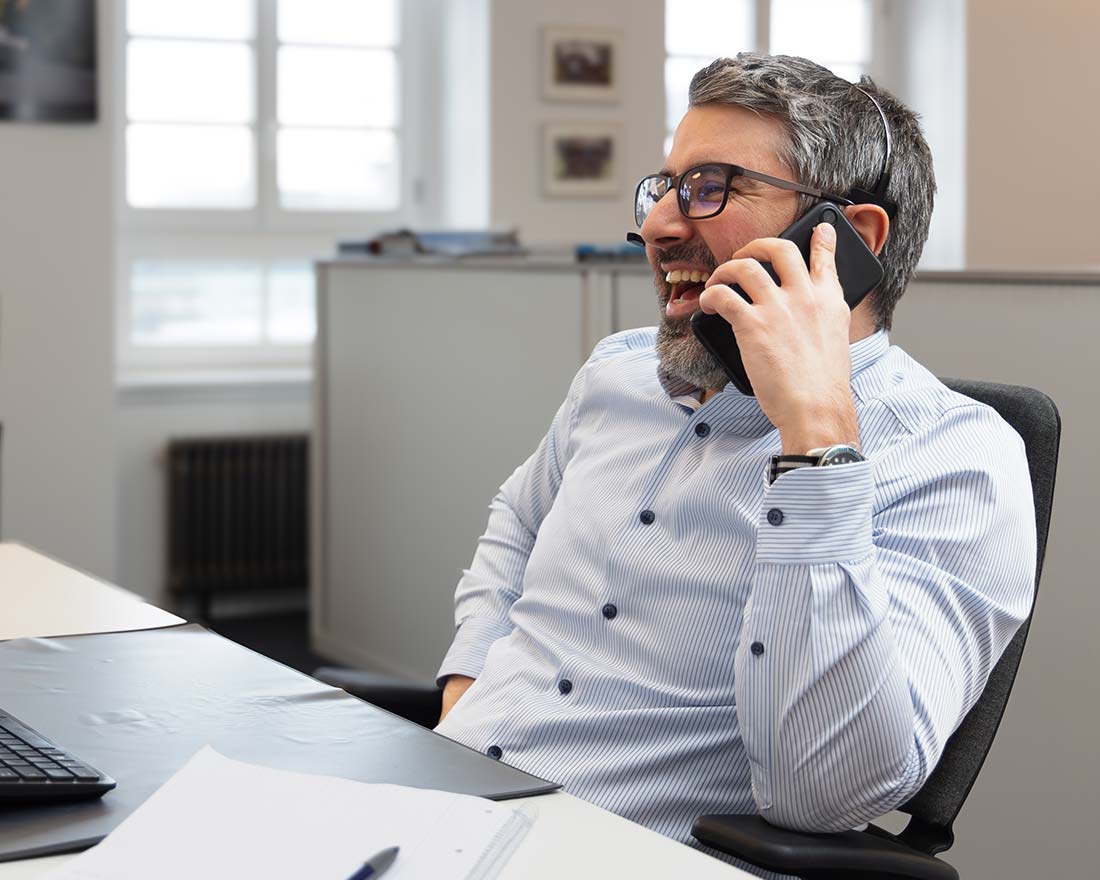 An employee at Frachtcontor Junge makes a phone call and enjoys his work